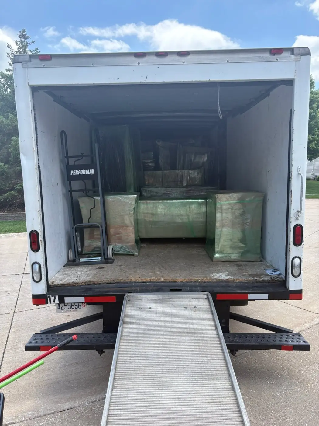 Shrink-wrapped furniture strapped inside the truck with the ramp down