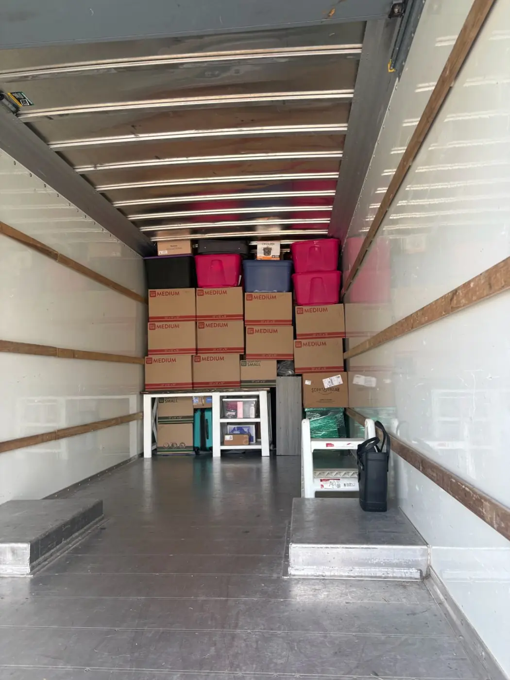 Moving truck packed floor to ceiling with labeled boxes and totes